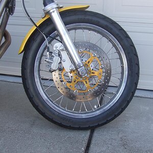 Front brake is Aprilia Tuono disc, Triumph 955i caliper and the front wheel ans spokes are from Mike's XS laced onto a stock hub that has the speedo d