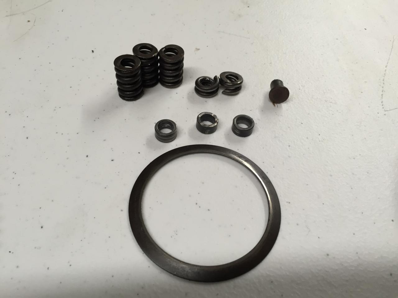 IMG 17- Here are what's left of original cush springs, only 4 out of six and 1 spring in pieces. The 3 steel washers in the middle, belong between the